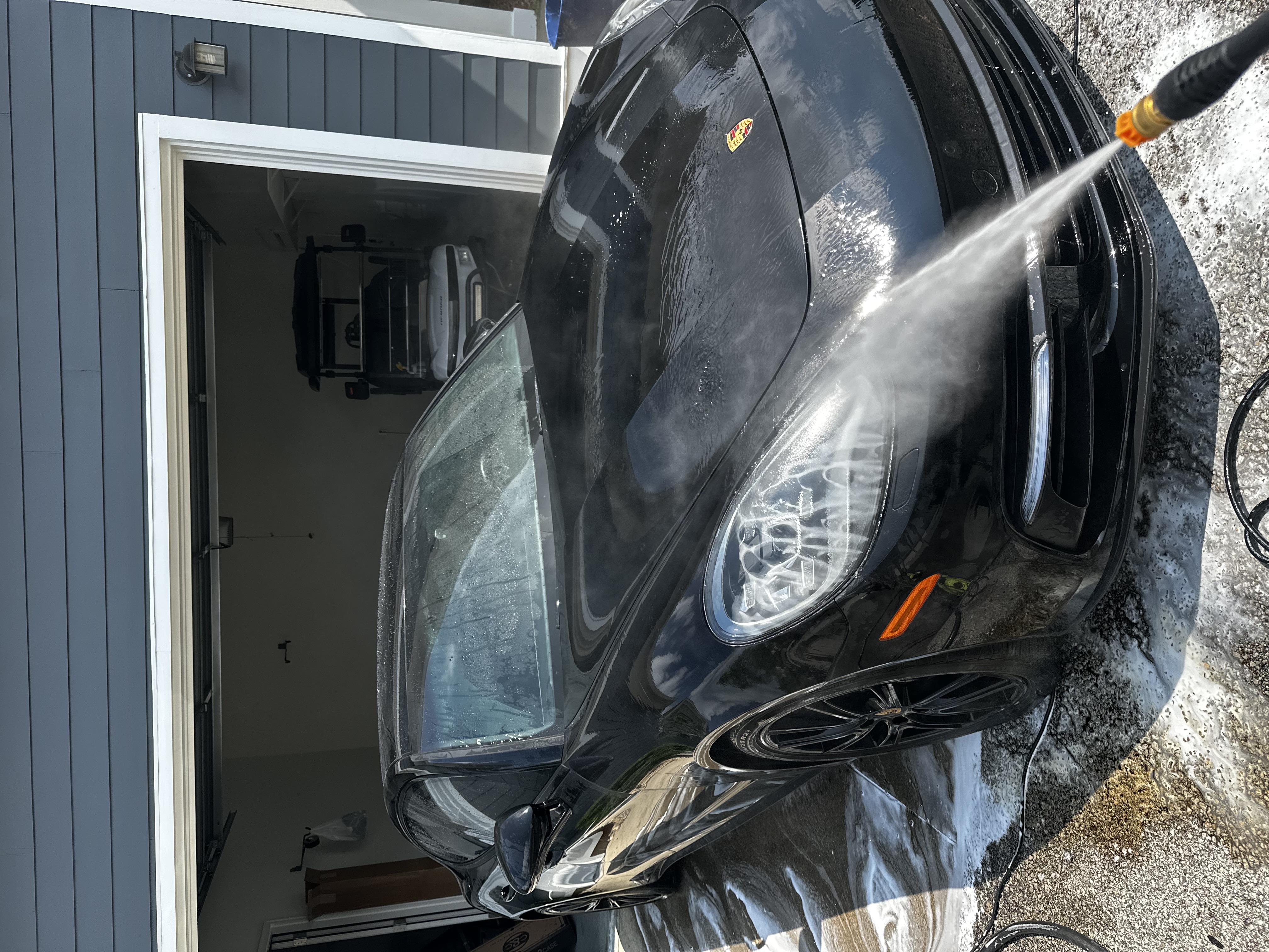 Pressure rinsing a Porsche during an exterior detail